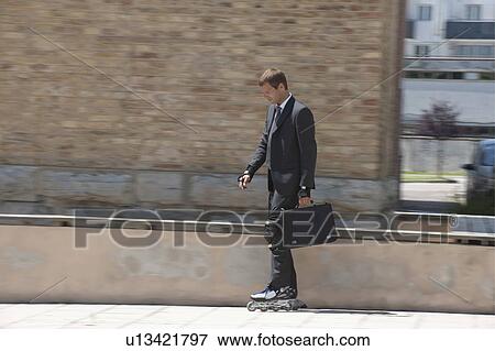 Businessman in suit inline skating View Large Photo Image Stock Photo - Businessman in suit inline skating. Fotosearch