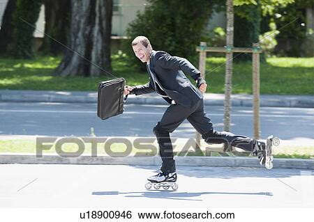 Businessman in suit inline skating View Large Photo Image Stock Photograph - Businessman in suit inline skating. Fotosearch