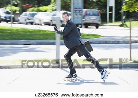 Stock Photograph - Businessman in suit inline skating. Fotosearch