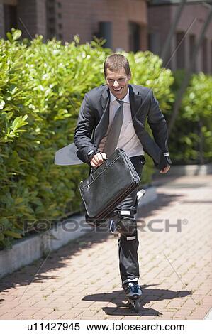 Businessman in suit inline skating View Large Photo Image Stock Photography - Businessman in suit inline skating. Fotosearch