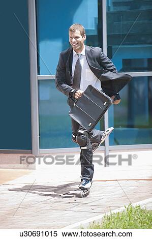 Stock Photography - Businessman in suit inline skating. Fotosearch