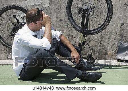 Businessman in suit next to broken bicycle View Large Photo Image Stock Image - Businessman in suit next to broken bicycle. Fotosearch