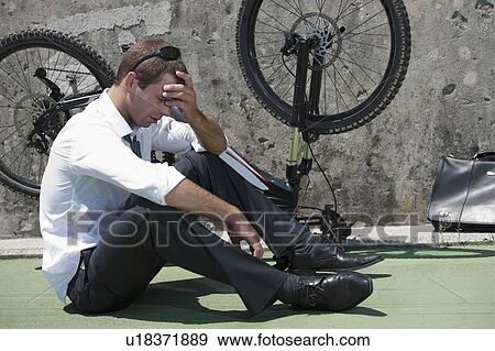 Businessman in suit next to broken bicycle View Large Photo Image Stock Photo - Businessman in suit next to broken bicycle. Fotosearch