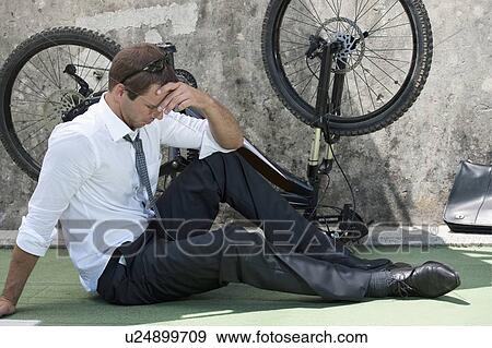 Businessman in suit next to broken bicycle View Large Photo Image Stock Photo - Businessman in suit next to broken bicycle. Fotosearch