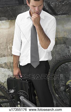 Businessman in suit next to broken bicycle View Large Photo Image Stock Photograph - Businessman in suit next to broken bicycle. Fotosearch
