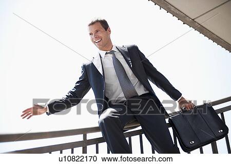 Businessman in suit sliding down bannister View Large Photo Image Stock Image - Businessman in suit sliding down bannister. Fotosearch