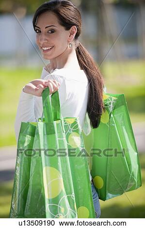 Stock Image - Casual woman with reusable shopping bags. Fotosearch