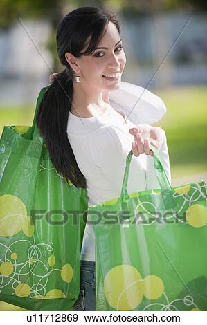 Stock Photo - Casual woman with reusable shopping bags. Fotosearch