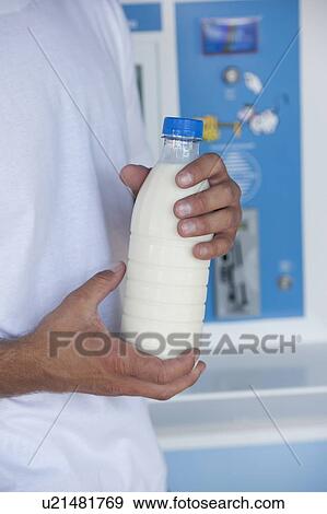 Closeup of man's hands holding milk bottle at cooler View Large Photo Image Stock Photo - Closeup of man's hands holding milk bottle at cooler. Fotosearch