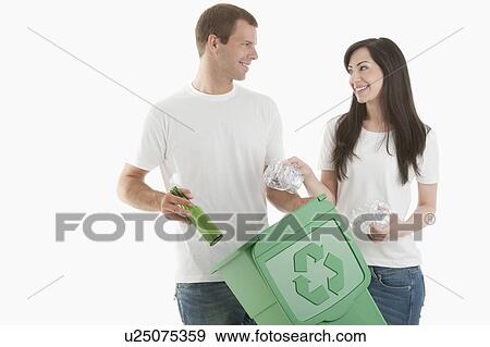 Couple throwing glass and plastic bottles in the recycling bin View Large Photo Image Stock Photo - Couple throwing glass and plastic bottles in the recycling bin. Fotosearch
