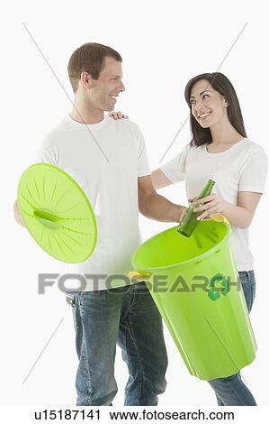 Couple throwing glass bottle in the recycling bin View Large Photo Image Stock Image - Couple throwing glass bottle in the recycling bin. Fotosearch