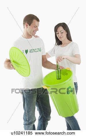 Couple throwing glass bottle in the recycling bin View Large Photo Image Stock Photography - Couple throwing glass bottle in the recycling bin. Fotosearch
