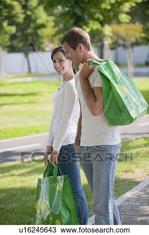 Stock Image - Couple with reusable shopping bags. Fotosearch