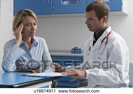 Stock Image - Doctor and patient discussing medical chart. Fotosearch