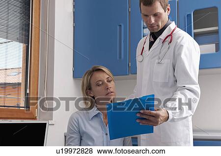 Doctor and patient discussing medical chart View Large Photo Image Stock Photo - Doctor and patient discussing medical chart. Fotosearch