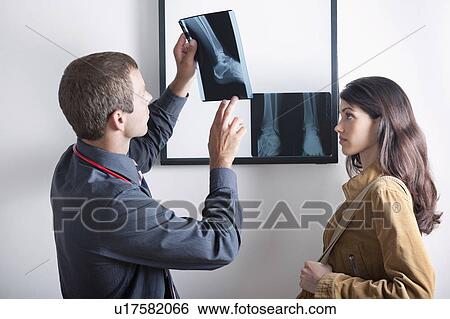 Stock Photograph - Doctor and patient looking at xray . Fotosearch