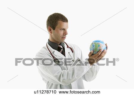 Doctor examining a globe View Large Photo Image Stock Image - Doctor examining a globe. Fotosearch