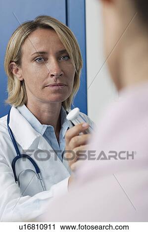 Stock Image - Doctor giving patient medicine. Fotosearch