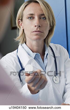 Stock Image - Doctor giving patient medicine. Fotosearch