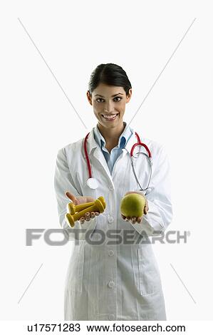 Doctor holding apple and hand weights View Large Photo Image Stock Image - Doctor holding apple and hand weights. Fotosearch