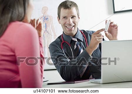 Doctor holding bottle of pills for patient View Large Photo Image Stock Image - Doctor holding bottle of pills for patient. Fotosearch