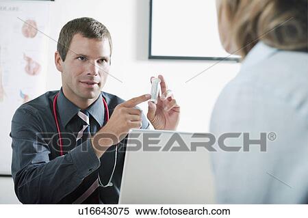 Stock Photography - Doctor holding bottle of pills for patient. Fotosearch