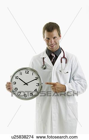 Doctor holding clock showing time View Large Photo Image Picture - Doctor holding clock showing time. Fotosearch