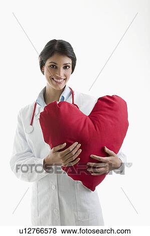 Stock Photo - Doctor holding heart pillow. Fotosearch