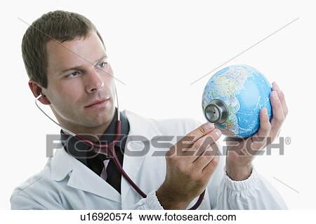 Doctor holding stethoscope to globe View Large Photo Image Picture - Doctor holding stethoscope to globe . Fotosearch