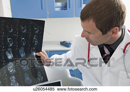 Stock Photography - Doctor looking at an MRI of ankle. Fotosearch