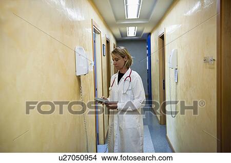 Picture - Doctor making telephone call in medical center. Fotosearch