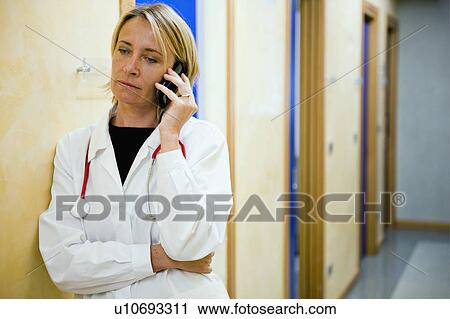 Stock Image - Doctor making telephone call in medical center. Fotosearch