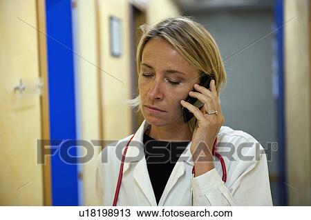 Stock Image - Doctor making telephone call in medical center. Fotosearch