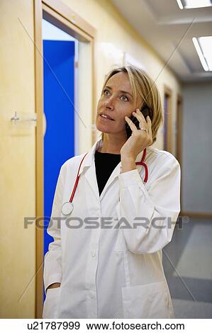 Doctor making telephone call in medical center View Large Photo Image Stock Photo - Doctor making telephone call in medical center. Fotosearch