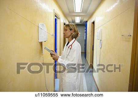 Doctor making telephone call in medical center View Large Photo Image Stock Photography - Doctor making telephone call in medical center. Fotosearch