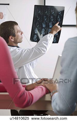 Stock Photography - Doctor showing MRI to patient . Fotosearch