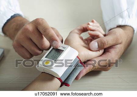 Doctor taking patient's blood pressure View Large Photo Image Stock Image - Doctor taking patient's blood pressure. Fotosearch