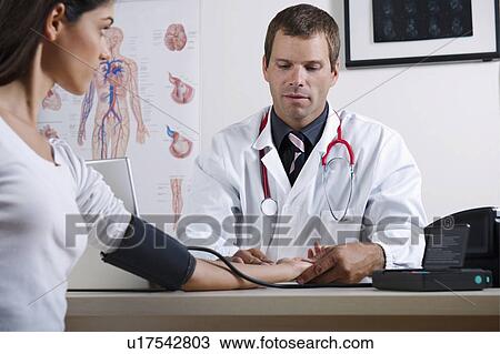 Doctor taking patient's blood pressure View Large Photo Image Stock Image - Doctor taking patient's blood pressure. Fotosearch