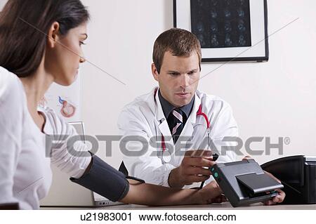 Doctor taking patient's blood pressure View Large Photo Image Stock Image - Doctor taking patient's blood pressure. Fotosearch