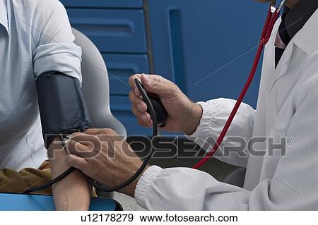 Doctor taking patient's blood pressure View Large Photo Image Stock Photo - Doctor taking patient's blood pressure. Fotosearch