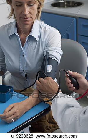 Stock Photo - Doctor taking patient's blood pressure. Fotosearch