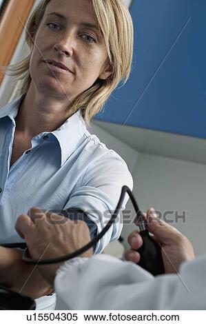 Doctor taking patient's blood pressure View Large Photo Image Stock Photography - Doctor taking patient's blood pressure. Fotosearch