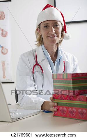 Doctor with laptop and Santa's hat View Large Photo Image Stock Image - Doctor with laptop and Santa's hat. Fotosearch