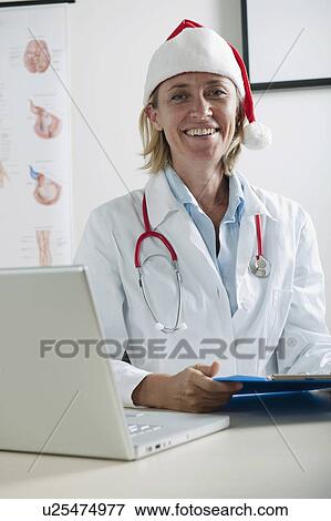 Doctor with laptop and Santa's hat View Large Photo Image Stock Photo - Doctor with laptop and Santa's hat. Fotosearch
