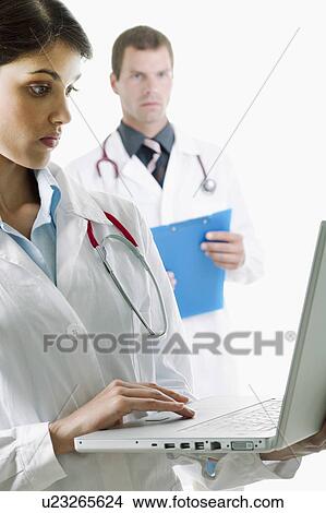 Picture - Doctor with laptop computer and doctor with medical chart. Fotosearch