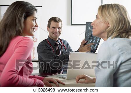 Stock Photo - Doctor with MRI of ankle and patients. Fotosearch