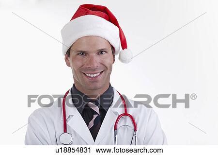 Stock Image - Doctor with stethoscope and Santa's hat. Fotosearch
