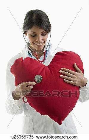 Doctor with stethoscope on heart pillow View Large Photo Image Stock Photography - Doctor with stethoscope on heart pillow. Fotosearch