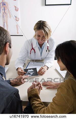 Doctor with ultrasound and couple View Large Photo Image Stock Image - Doctor with ultrasound and couple. Fotosearch