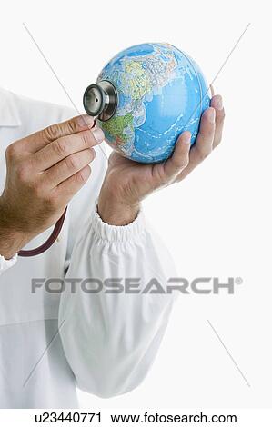 Stock Image - Doctor's hands holding stethoscope to globe . Fotosearch